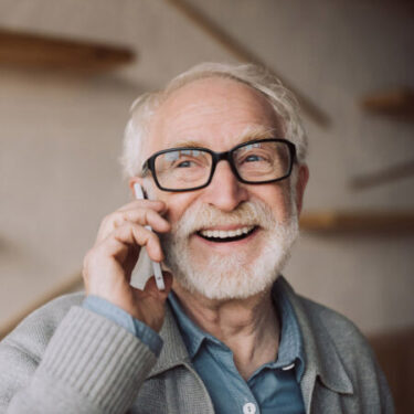 older man with glasses on phone